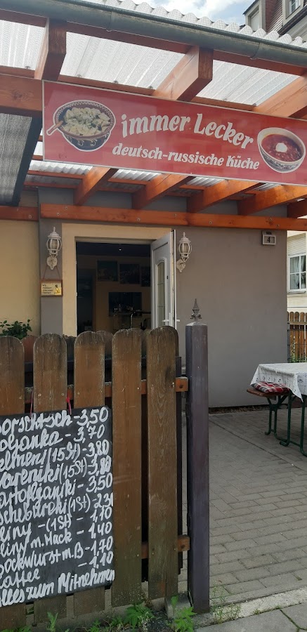 Ladenfront mit Schriftzug immer Lecker deutsch-russische Küche und Kreidetafel am Zaun