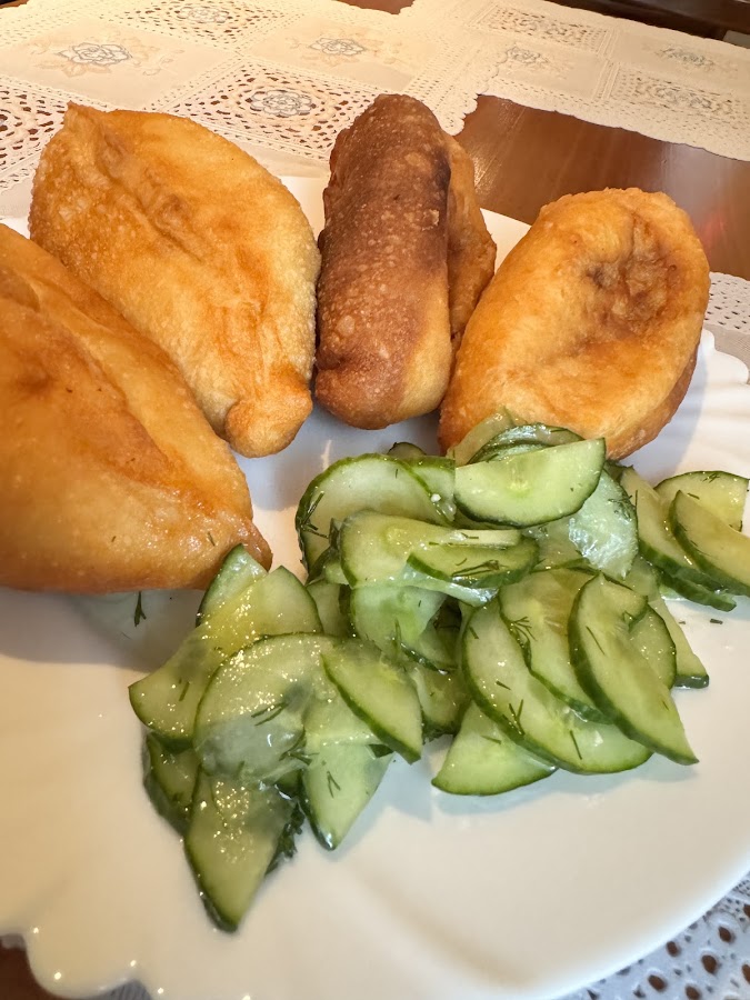 Tschebureki mit Gurkensalat auf Teller